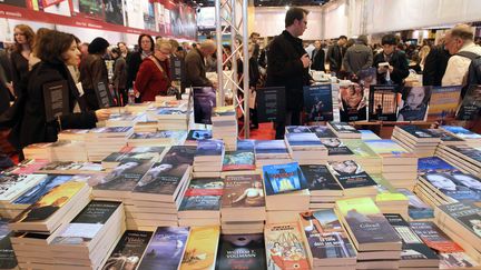 Des personnes consultent des ouvrages sur un stand, le 28 mars 2010 &agrave; la Porte de Versailles &agrave; Paris, lors du Salon du Livre. (PIERRE VERDY / AFP)