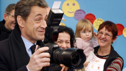 Le pr&eacute;sident fran&ccedil;ais Nicolas Sarkozy prend en photo des enfants lors de la visite d'une cr&ecirc;che &agrave; Lavaur (Tarn), le 7 f&eacute;vrier 2012. (MICHEL EULER / AFP)