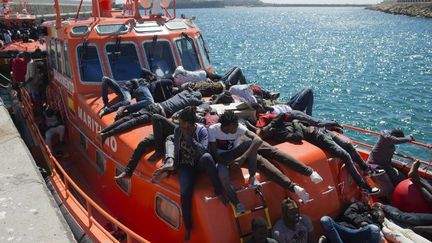 Des migrants attendent d’être transférés après leur arrivée à bord d’un bateau au port de Tarifa le 26 juillet 2018, après que leur bateau pneumatique eut été sauvé par les garde-côtes espagnols en mer Méditerranée. (JORGE GUERRERO / AFP)