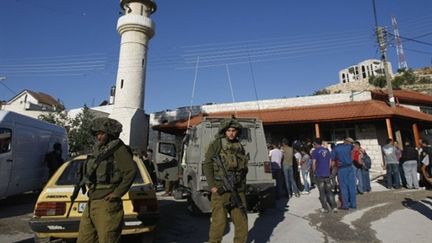 Soldats israéliens et civils palestiniens aux abords d'une mosquée touchée par un incendie, en Cisjordanie (04/05/10) (AFP / Jaafar Ashtiyehé)