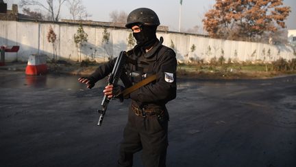 Un policier afghan près du ministère des Travaux publics à Kaboul (Afghanistan), au lendemain d'une attaque qui a fait au moins 43 morts.&nbsp; (WAKIL KOHSAR / AFP)