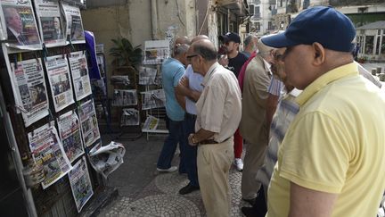 A&nbsp;Alger, le 16 septembre 2019, des passants regardent les unes des journaux nationaux et étrangers annonçant la date de l'élection présidentielle. (RYAD KRAMDI / AFP)