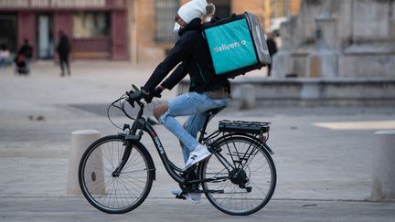 Un livreur à vélo circule à Aix-en-Provence (Bouches-du-Rhône), le 17 mars 2020. (CLEMENT MAHOUDEAU / AFP)