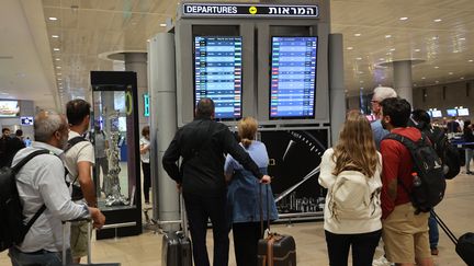 Passengers look at the departure board at Ben Gurion Airport near Tel Aviv, Israel, October 7, 2023, Illustrative photo.  (GIL COHEN-MAGEN / AFP)