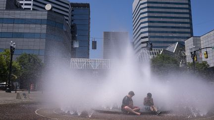 Des enfants dans une fontaine de Portland (Etats-Unis) pour échapper à la chaleur, le 27 juin 2021. (NATHAN HOWARD / GETTY IMAGES NORTH AMERICA / AFP)