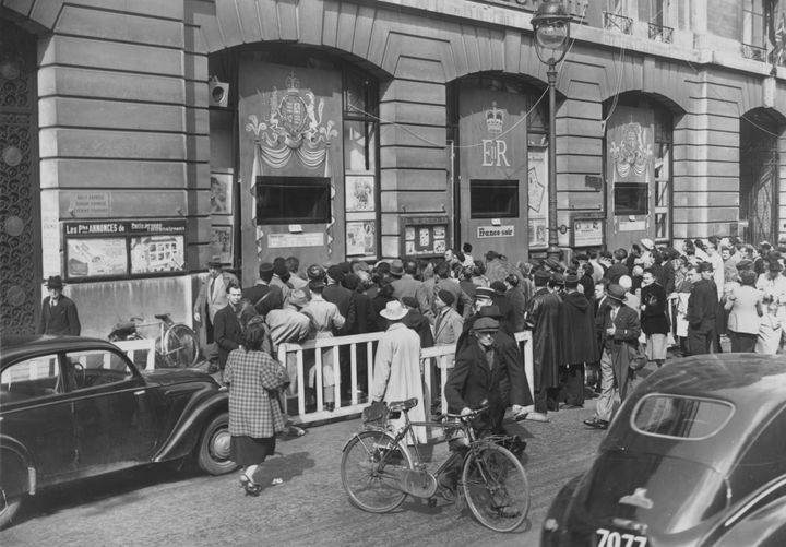 Des Parisiens se pressent autour&nbsp;des&nbsp;fenêtres du siège du "Figaro" pour regarder le couronnement d'Elizabeth II&nbsp;à la télévision, le 2 juin 1953 à Paris. (KEYSTONE / HULTON ROYALS COLLECTION / GETTY IMAGES)