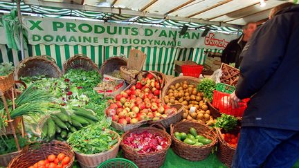 Une personne choisit des légumes provenant de la culture biologique, le 19 novembre 2000 dans un marché de Paris. (JEAN-PIERRE MULLER / AFP)