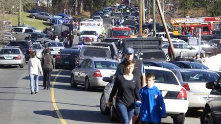 Des parents viennent chercher leurs enfants apr&egrave;s la fusillade de l'&eacute;cole de Newtown (Connecticut), le 14 d&eacute;cembre 2012. (MICHELLE MCLOUGHLIN / REUTERS)