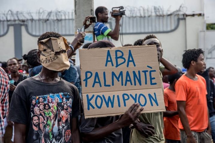 Des manifestants brandissent une pancarte disant «&nbsp;À bas les législateurs corrompus&nbsp;» lors d’une manifestation de l’opposition et exigeant la démission du président Jovenel Moise, à Port-au-Prince, Haïti, le 18&nbsp;novembre 2019.  (VALERIE BAERISWYL/AFP)