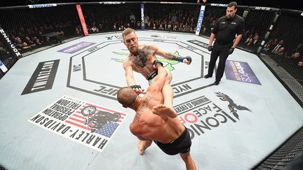 L'une des stars du MMA, Conor McGregor (de face),&nbsp;affronte&nbsp;l'Américain Eddie Alvarez lors du championnat du monde poids légers&nbsp;au Madison Square Garden de&nbsp;New York (Etats-Unis), le 12 novembre 2016. (JEFF BOTTARI / ZUFFA LLC / GETTY IMAGES)