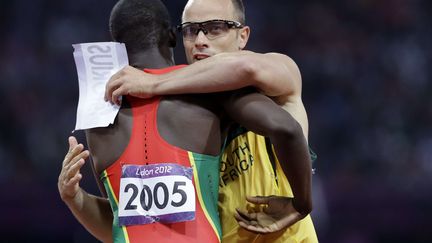 Oscar Pistorius, premier amput&eacute; align&eacute; aux Jeux,&nbsp;&eacute;change son dossard avec le champion du monde&nbsp;Kirani James apr&egrave;s sa demi-finale du 400 m conclue &agrave; la derni&egrave;re place mais sous l'ovation du public. (ANJA NIEDRINGHAUS/AP/SIPA / AP)