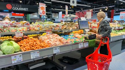 Une cliente dans le rayon fruits et légumes d'un supermarché à Paris, le 28 juillet 2022. (RICCARDO MILANI / HANS LUCAS / AFP)