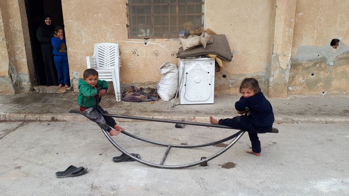 Des enfants jouent devant les coursives du&nbsp;stade municipal d'Idlib,&nbsp;transformées en dortoirs. (AURELIEN COLLY / RADIO FRANCE)