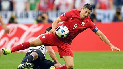 Le Polonais Robert Lewandoski tacle le défenseur allemand&nbsp;Mats Hummels, lors du match Allemagne-Pologne, au Stade de France à Saint-Denis, le 16 juin 2016. (PATRIK STOLLARZ / AFP)