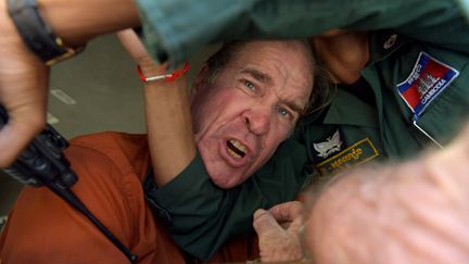 Le cinéaste australien James Ricketson, condamné pour espionnage, essaie de s'adresser à la presse à la sortie du tribunal, à Phnom Penh (Cambodge), le 31 août 2018. (TANG CHHIN SOTHY / AFP)