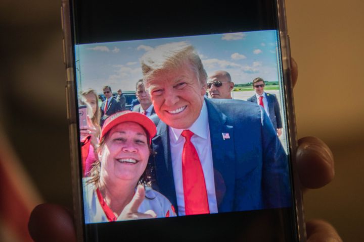 Cindy Hoffman montre un cliché où elle pose à côté du président Donald Trump, le 21 octobre 2018, dans un bar de l'Iowa.&nbsp; (VALENTINE PASQUESOONE / FRANCEINFO)