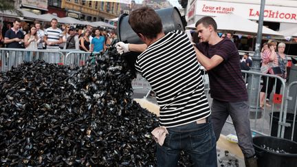 Deux hommes renversent des coquilles de moules, le 3 septembre 2016, à Lille. (FRÉDÉRIC DESCHAMPS / CITIZENSIDE / AFP)