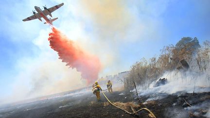 Un bombardier disperse une substance ignifuge pour aider les pompiers &agrave; circonscrire l'incendie de for&ecirc;t qui menace des habitations &agrave; Santa Rosa (Californie, Etats-Unis), le 10 juillet 2013. (KENT PORTER / AP / SIPA)