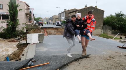 Une femme est évacuée, le 15 octobre 2018, à Villegailhenc (Aude). (ERIC CABANIS / AFP)