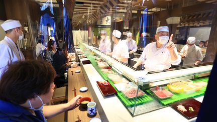 Des clients prennent leur repas dans un restaurant de sushis d'un marché de Tokyo (Japon), le 8 juin 2020. (KEITA IIJIMA / YOMIURI / AFP)