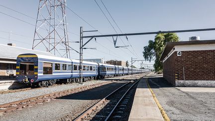 Obligé de casser ses prix pour pouvoir remplir ses luxueux wagons, le Blue Train sud-africain, qui a été inauguré en 1923, est aujourd’hui principalement fréquenté par des autochtones. Mais malgré la baisse des tarifs, seules les classes aisées peuvent encore en profiter, car un voyage coûte a minima quelque 1300 euros par personne en pension complète, une petite fortune dans un pays aux fortes disparités, précise l’AFP. Le revenu mensuel moyen par habitant s'élève à 420 euros.&nbsp; &nbsp; (MARCO LONGARI / AFP)