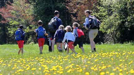 Des enfants se baladent dans la nature, accompagnés par deux adultes, le 21 mai 2020. (VANESSA MEYER / MAXPPP)