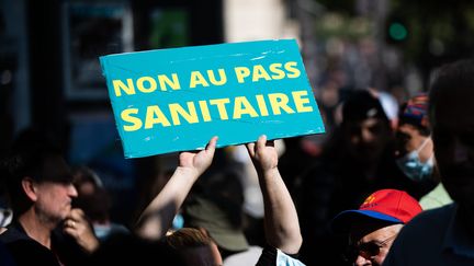 Un manifestant brandit un panneau anti-pass sanitaire lors d'un rassemblement devant le Sénat, jeudi 22 juillet.&nbsp; (ALEXIS SCIARD / MAXPPP)