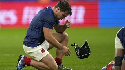 Le rêve vole en éclats. Antoine Dupont retire le casque censé protéger sa joue meurtrie face à la Namibie. Il n'aura pas porté chance au capitaine des Bleus qui accuse le coup après le quart de finale perdu d'un point face à l'Afrique du Sud, le 15 octobre 2023 (28-29). (SIPA)