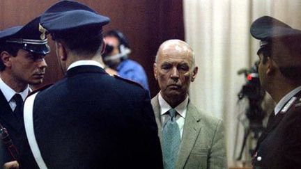 L'ancien capitaine SS Erich Priebke entouré par des carabiniers italiens au tribunal militaire de Rome le 1-8-1996. (Reuters - Paolo Cocco)