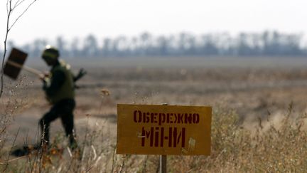 &nbsp; (Un soldat ukrainien balise un terrain miné à côté de Marioupol où des bombardements survenus au cours de la nuit ont coûté la vie à une femme de 33 ans © Maxppp)