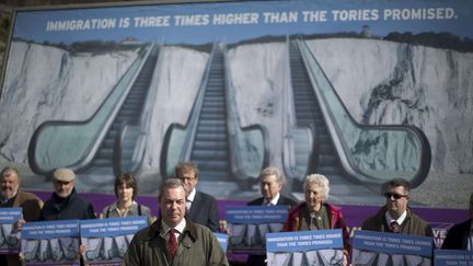 Le leader du Ukip, Nigel Farage, le 31 mars 2015, au pied des falaises de Douvres pour pr&eacute;senter l'affiche de son parti : "L'immigration est trois fois plus importante que ce que les Tories avaient promis", dit le slogan. (MATT DUNHAM / AP / SIPA)