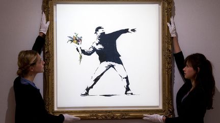 L'oeuvre du street artist britannique Banksy est pr&eacute;sent&eacute;e avant d'&ecirc;tre mise en vente aux ench&egrave;res &agrave; Londres (Royaume-Uni), le 24 juin 2013. (BANKSY / JUSTIN TALLIS / AFP)