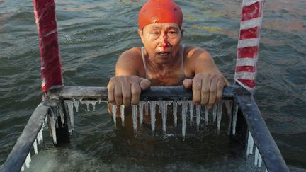 Une femme sort de l'eau en saignant apr&egrave;s s'&ecirc;tre bless&eacute;e l&eacute;g&egrave;rement en nageant dans les eaux glac&eacute;es de la rivi&egrave;re Songhua &agrave; Harbin (Chine), le 5 janvier 2012. (SHENG LI / REUTERS)