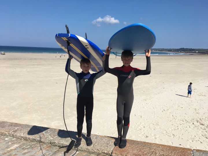 Alexandre et son grand frère Mathieu font du surf sur une plage à Saint-Ouen, commune de l'île anglo-normande de Jersey. (INGRID POHU / RADIO FRANCE)