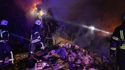 Les pompiers tentent d'éteindre l'incendie d'un bâtiment après une frappe russe, le 31 décembre 2023, à Kharkiv, en Ukraine. (YEVHEN TITOV / ANADOLU / AFP)