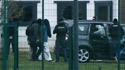 Une personne menottée est escortée par les forces de l'ordre, le 5 mars 2019, au centre pénitentiaire de Condé-sur-Sarthe (Orne). (JEAN-FRANCOIS MONIER / AFP)