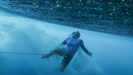 La Portugaise Yolanda Hopkins s'effondre dans une vague, à Teahupo'o, lors du deuxième tour féminin des JO, le 28 juillet 2024. (BEN THOUARD / AFP)