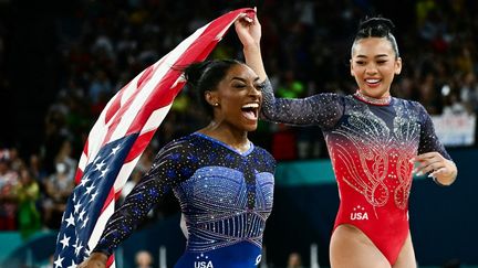 Simone Biles (à gauche) et sa compatriote Sunisa Lee, à l'issue de la finale du concours général individuel femmes aux Jeux olympiques de Paris 2024, à l'Arena de Bercy, le 1er août 2024, (LOIC VENANCE / AFP)