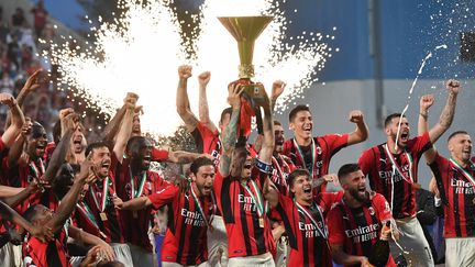 Le capitaine de l'AC Milan Alessio Romagnoli soulève le Scudetto qui symbolise leur titre de champion d'Italie, à Sassuolo, le 22 mai 2022. (TIZIANA FABI / AFP)