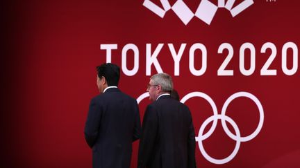 Le Premier ministre japonais, Shinzo Abe, aux côtés du président du CIO, Thomas Bach, le 24 juillet 2019, lors d'un événement organisé dans la capitale Tokyo. (BEHROUZ MEHRI / AFP)