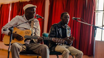 Oliver "Tuku" Mtukudzi avec un "élève" du centre "Pakare Paye" en janvier 2018. 
 (JEKESAI NJIKIZANA / AFP)