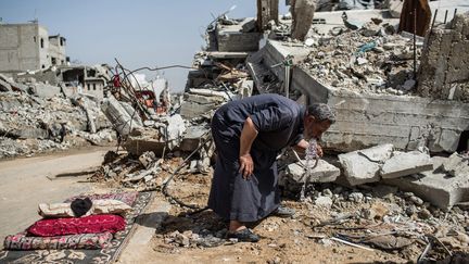 &nbsp;Gaza. Février 2015. 
Un homme s’est installé devant les ruines de sa maison. Il a perdu son fils lors de l'opération bordure protectrice de l'été 2014. Il a réussi à raccorder l'eau d'un puits avec un tuyau. Mais celle-ci provient directement de l’aquifère côtier, qui est pollué à 96%. En effet, largement sur-exploité en amont, l’aquifère est infiltré par l'eau de mer et par les eaux sales. (© Laurence Geai / Sipa Press)