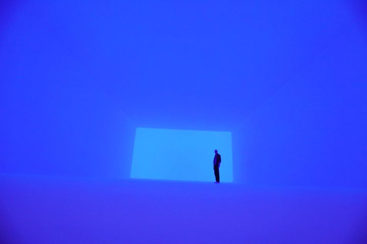 Un homme s'immerge dans l'installation lumineuse "Aural" de James Turrell au Musée juif de Berlin, le 12 avril 2018. (WOLFGANG KUMM / AFP)