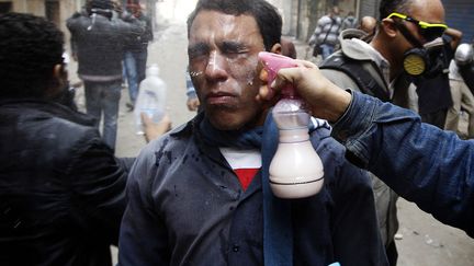 Un manifestant se fait vaporiser du lait sur les yeux afin de limiter les effets des gaz lacrymog&egrave;nes place Tahrir au Caire (Egypte), le 22 novembre 2011. (GORAN TOMASEVIC / REUTERS)