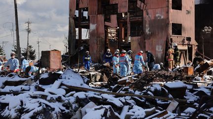 Des secouristes recherchent des disparus à Wajima, au Japon, le 7 janvier 2024. (DAISUKE TOMITA / YOMIURI / AFP)