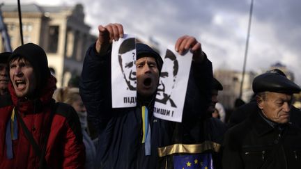 Un manifestant d&eacute;chire un portrait du pr&eacute;sident ukrainien, Viktor Yanukovitch, sur la place de l'Ind&eacute;pendance, &agrave; Kiev, vendredi 29 novembre 2013.&nbsp; (STOYAN NENOV / REUTERS )