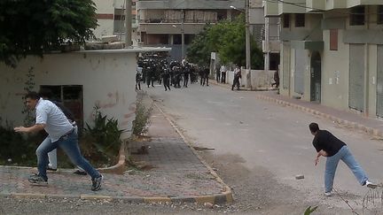 Des hommes jettent des pierres sur les forces de l'ordre &agrave; Banias, en Syrie, le 27 mai 2011. ( AFP )