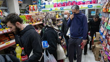 Des habitants d'Istanbul font la queue dans une petite épicerie, le 10 avril 2020, après l'annonce surprise d'un confinement de 48 heures dans les principales villes de Turquie. (YASIN AKGUL / AFP)