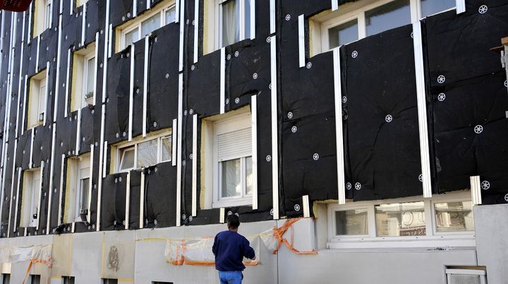 Un ouvrier installe des panneaux d'isolant sur la fa&ccedil;ade d'un immeuble &agrave; Nantes (Loire-Atlantique), le 25 mars 2013. (ALAIN LE BOT / AFP)