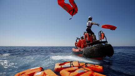 Des membres de l'ONG SOS Méditerranée et Médecins Sans Frontières (MSF) réalisent un exercice de sauvetage près du navire de sauvetage Aquarius, en pleine mer entre Lampedusa et la Tunisie, le 23 juin 2018 . (PAU BARRENA / AFP)